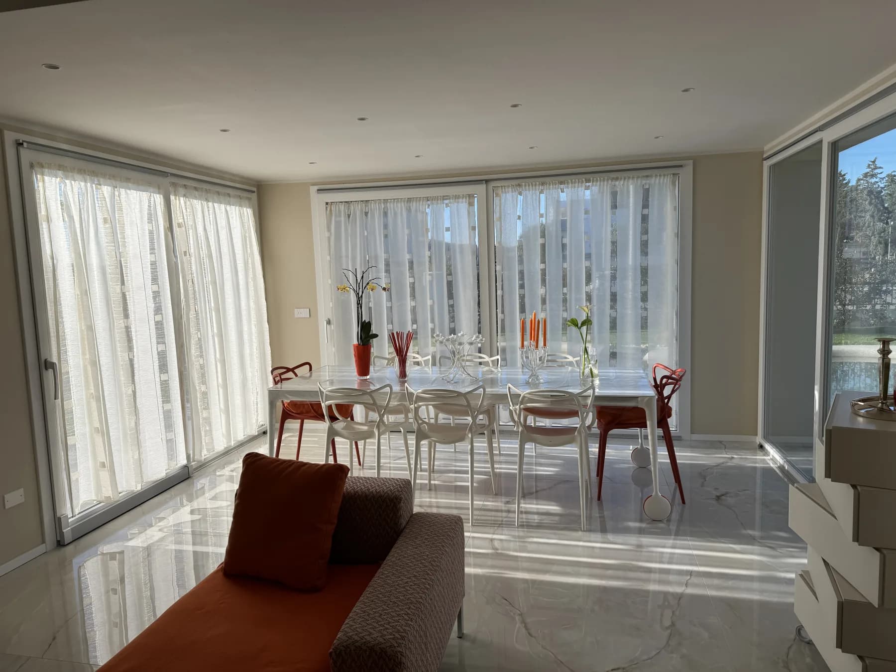 Bright open-plan dining and living extension with white marble flooring and floor-to-ceiling windows — a seamless home addition by Cappelli Interiors