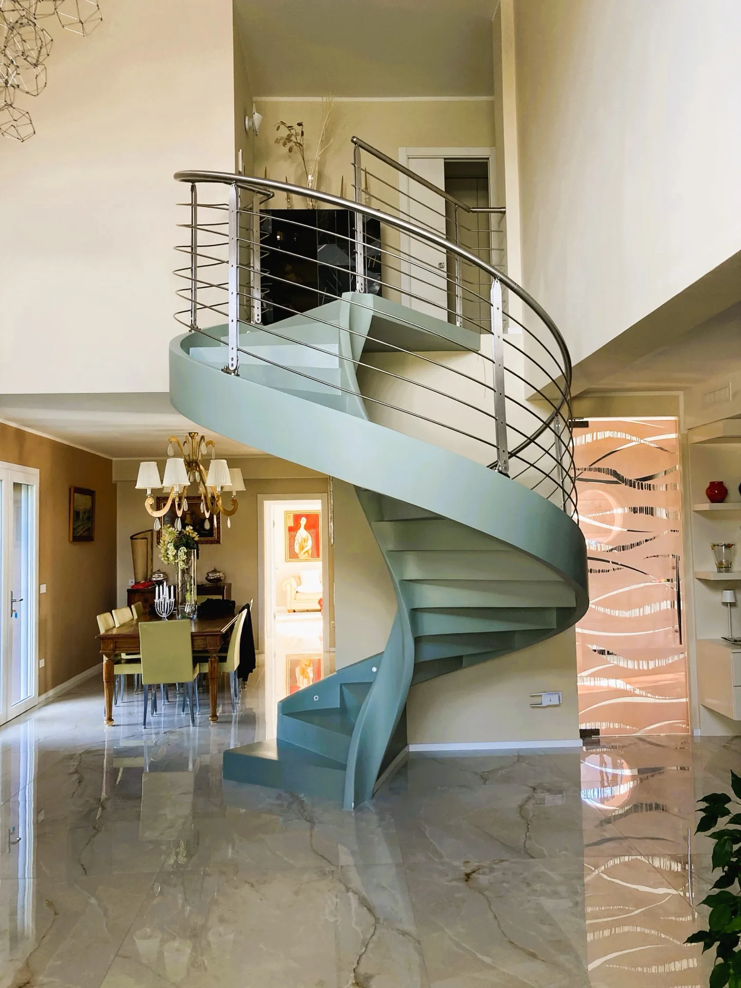 Central staircase of the completed villa, dining room beyond